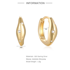 Detailed view of gold S925 silver star huggie earrings with AAA zirconia inlay