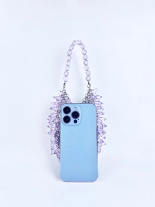 Macro shot of purple faceted crystal beads and tassel detail on a luxury evening handbag