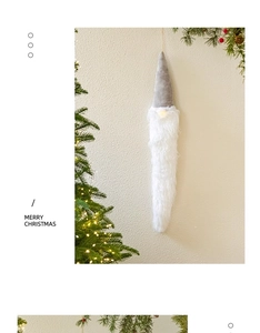 Glowing long-bearded Christmas gnome hanging ornament with warm light on white wall