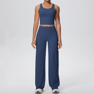Dettaglio set yoga blu scuro con canotta sportiva aderente e pantaloni sportivi larghi