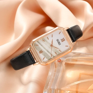 Macro shot of rectangular rose gold watch with marble dial and black leather strap