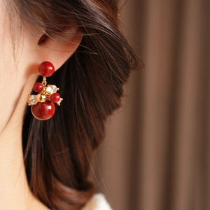 Dettaglio di orecchini a fiore con zircone rosso vintage e placcatura oro 18 carati