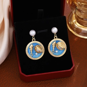 Dettaglio macro di orecchini vintage con conchiglia e perle in confezione lusso