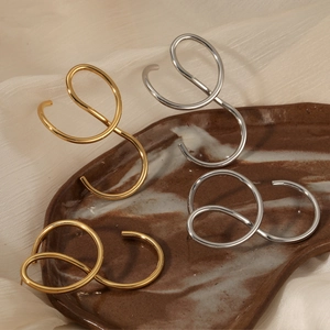 Irregular line stainless steel earrings in gold and silver finish shown on ceramic tray