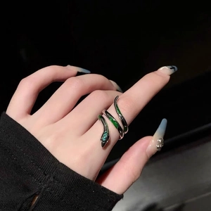 Détail de la bague serpent en argent avec émail vert et pierres bleues sur le doigt