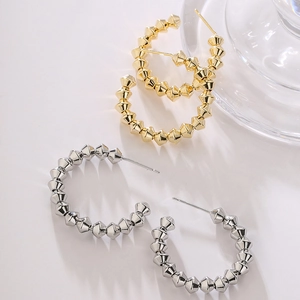 Minimalist gold and silver C-shaped hoop earrings with geometric pyramid spike design