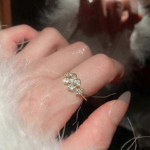 Macro shot of gold flower ring with zircon stones on a model wearing white fur sleeve