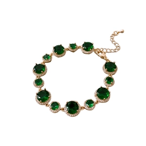 Vintage gold plated bracelet featuring round emerald green zircons and pavé halo crystals