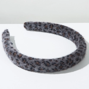 Detail view of plush leopard print headband with shimmering fibers and soft faux fur texture
