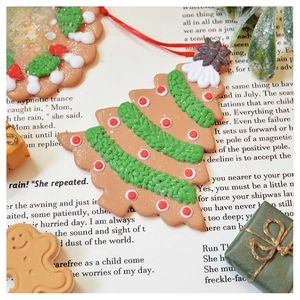 Detailed view of gingerbread style Christmas tree ornaments on vintage text background
