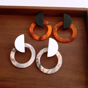 Macro shot of geometric acrylic earrings with tortoiseshell and marble textures