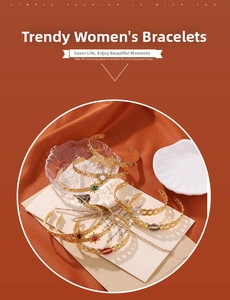 Detail of gold geometric C-shaped bangles with zircon and natural stones on glass tray