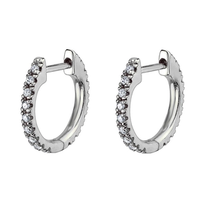 Gros plan détaillé de boucles d'oreilles créoles argentées serties de zircons sur fond blanc