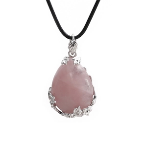 Macro view of pink teardrop crystal pendant with silver leaf pattern metal setting