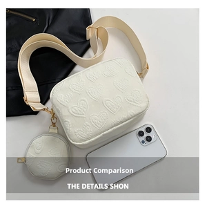 Detail of cream crossbody bag featuring embossed heart patterns and a round coin purse