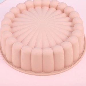 Detailed view of pink round silicone cake mold with grooved sides for baking
