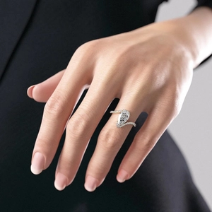 Detail of a pear-shaped white zircon ring with gold plating and micro-pave setting