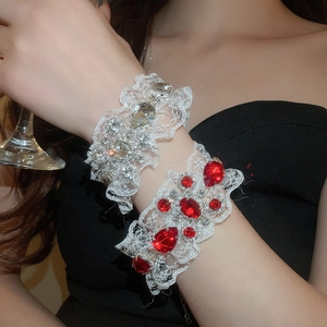 Détail d'un bracelet en dentelle élégant avec cristaux rouges en goutte et dentelle florale