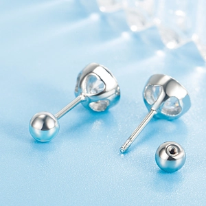 Elegant silver screw-back stud earrings with round cubic zirconia on light blue background