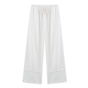 Detail of white wide-leg linen trousers featuring an adjustable drawstring waistband
