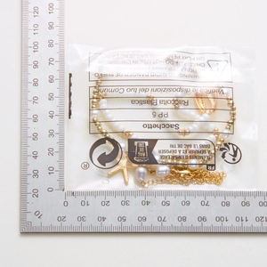 Detail of bohemian gold anklet with pearls, starfish and shell charms in packaging