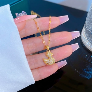 Golden titanium steel necklace with a zircon-encrusted duck pendant in a lifestyle setting