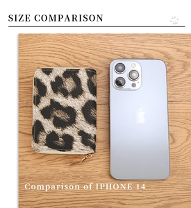 Size comparison between leopard print accordion wallet and iPhone 14 on wood background