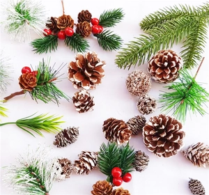 Flat lay of Christmas pine cones with snow effect, pine needles and red berries