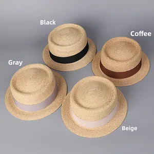 Flache Strohhüte in vier Farben mit dekorativen Bändern in Schwarz und Beige
