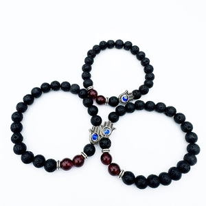 Three-piece black lava stone bead bracelet set with red agate and evil eye hand charm