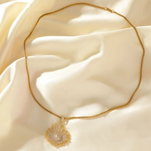 Gold sunflower pendant necklace with zircon stones on premium white silk background