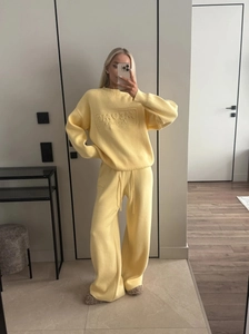 Detail of yellow knit loungewear set showing waffle texture and loose fit pants