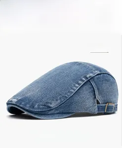 Detail of blue washed denim beret featuring a vintage bronze side adjustment buckle