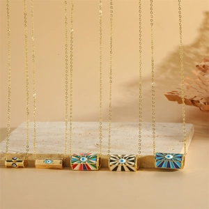 Gold necklaces with diverse cylindrical evil eye pendants on a natural stone base