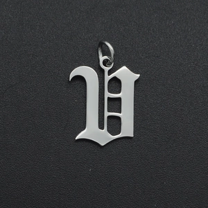 Detailed view of a silver Gothic letter V pendant made of polished stainless steel