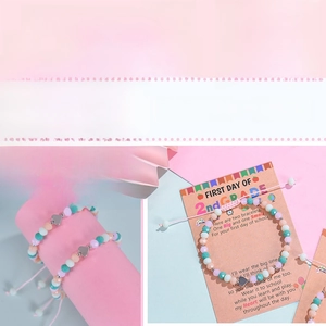 Gros plan de bracelets en perles avec pendentif cœur sur carte cadeau rentrée scolaire