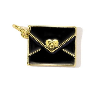 Macro shot of an envelope-shaped pendant with a gold heart seal on a black background