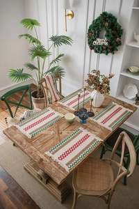 Close-up of red and green striped woven cotton table runners with tassels and placemats