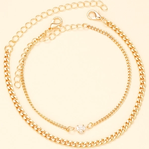 Detail of gold double-layer anklet set with cuban chain and heart zircon pendant