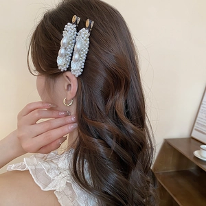 French style pearl hair clip set and gold hoop earrings on model with wavy hair