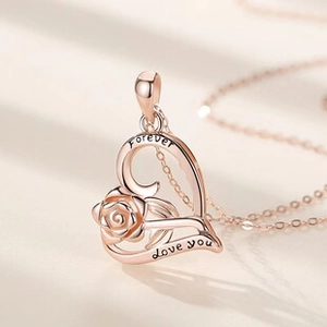 Detail of rose gold heart pendant with rose inside and Forever Love you engraving
