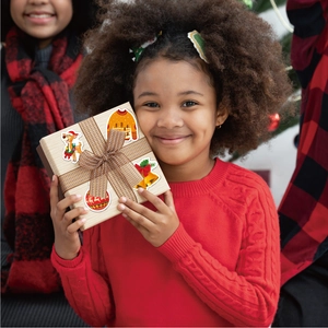 Holographic Christmas stickers featuring reindeer and bells used on a festive gift box