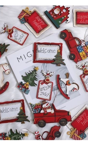 Close-up of assorted wooden Christmas ornaments including red truck and snowmen designs