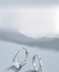 Detail showing S925 sterling silver stamp and polished texture on round zircon earrings