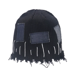 Distressed black ribbed knit beanie with denim patches and raw fringe edge detail