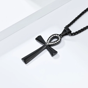 Close-up of black Ankh cross pendant featuring clear crystals on a sleek metal chain