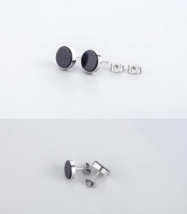 Macro view of round blue sandstone earrings with polished titanium steel base details