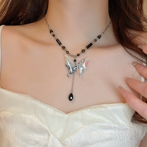 Close-up of vintage butterfly pendant necklace with sun and star zircon on a female neck