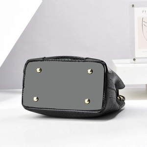 Detailed view of crocodile pattern bucket bag bottom with four gold protective metal feet