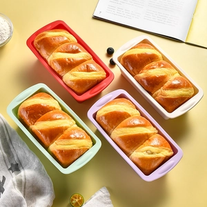 Rectangle silicone bread loaf pans in four colors with fresh baked golden bread inside